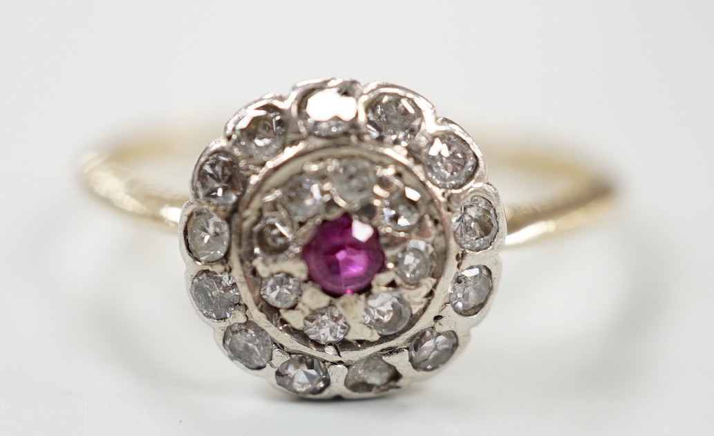 An early to mid 20th century, yellow metal ruby and diamond set target cluster ring, size P, gross weight 2.8 grams.